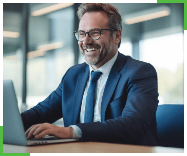 Man smiling and laughing in business suit and looking at a computer screen