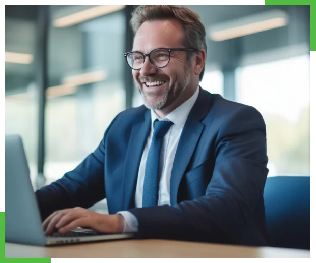 Man smiling and laughing in business suit and looking at a computer screen